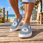 NB Trucks Checkerboard Slip-Ons worn on a beach boardwalk